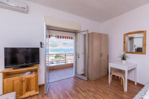 een woonkamer met een televisie en een tafel met een bureau bij Belvedere Naxos 9 in Giardini Naxos