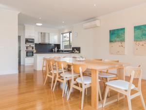 a kitchen and dining room with a wooden table and chairs at Retreat on Albert in Cowes