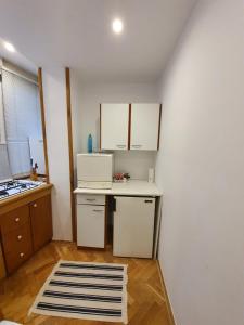 une petite cuisine avec un comptoir blanc et une table dans l'établissement Ultracentral Apartments, à Bucarest