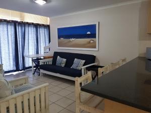 a living room with a couch and a table at Point Village Accommodation - Santos 18 in Mossel Bay