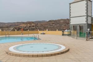 duży basen w ceglanym patio z budynkiem w obiekcie Apartamento Happy Dreamer w mieście Puerto Rico de Gran Canaria