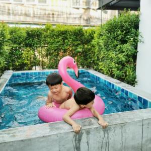 two boys on inflatables in a swimming pool at Stay Here Hostel in Chiang Mai +21 photos