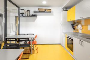 - une cuisine avec des sols jaunes, une table et des chaises dans l'établissement Youth Hostel Trbovlje, à Trbovlje