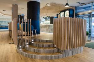 a spiral staircase in a office lobby with wooden pillars at Suites Plaza Hotel & Wellness in Andorra la Vella