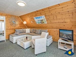 a living room with a couch and a television at Haus Ueckeritz Loggiawohnung in Ueckeritz