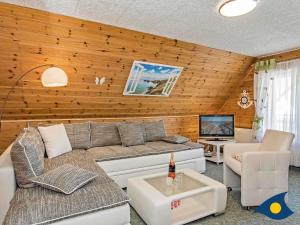 a living room with a couch and a tv at Haus Ueckeritz Loggiawohnung in Ueckeritz