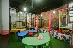 The Bountie Hotel and Convention Centre Sukabumi في سوكابومي: منطقة لعب للأطفال مع طاولات وكراسي ملونة