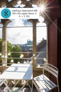 a table and a chair on a balcony with a view at statthaus - statt hotel in Cologne +99 photos