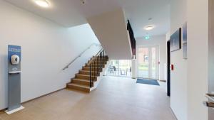 einen Flur mit Treppe in einem Haus in der Unterkunft WH Hotels Papenburg Zentrum in Papenburg