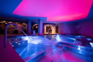 a room with a hot tub with pink lighting at Grand Plaza Hotel & Wellness in Andorra la Vella