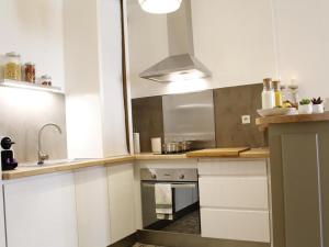 cocina con armarios blancos y horno en Le relais de la maison Bacou, en Carcassonne