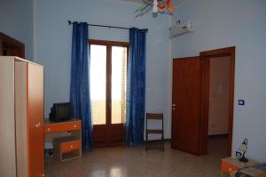 Habitación con TV, escritorio y ventana. en casa susanna en Matino