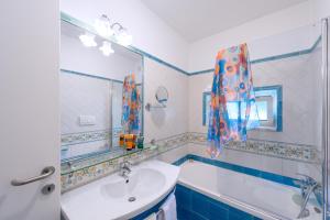 a bathroom with a sink and a tub and a mirror at Amalfi Suite Boutique Hotel in Amalfi