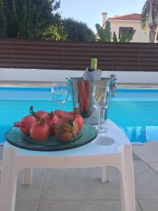 a plate of fruit on a table next to a pool at Katikies 14 Beach Villa in Pissouri