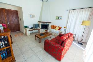 Una sala de estar con un sofá rojo y una chimenea. en Prengos Villas, en Pafos