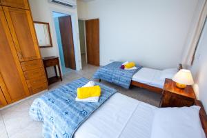 1 dormitorio con 2 camas y vestidor con lámpara en Prengos Villas, en Pafos 6 fotos más
