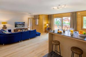 un soggiorno con divano blu e tavolo di Coin des Drus Apartment - Chamonix All Year a Chamonix-Mont-Blanc