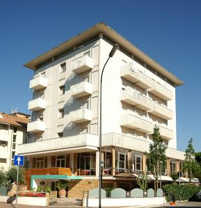een wit gebouw met een straatlicht ervoor bij Hotel Casali in Cervia