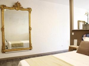 a bedroom with a gold mirror on the wall at Maison Bacou N1 in Carcassonne