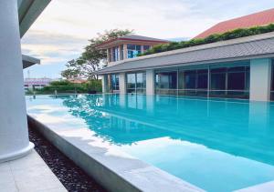 a swimming pool in front of a building with blue water at Krungsri River Hotel in Phra Nakhon Si Ayutthaya