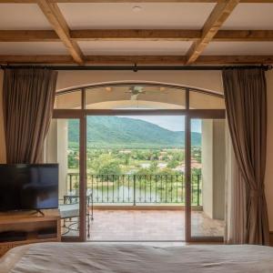 a bedroom with a large glass door leading to a balcony at Toscana Town Square Suites in Mu Si