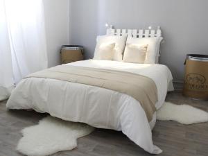 a white bed with white blankets and pillows on it at Maison Bacou N2 in Carcassonne