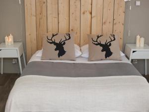 a bed with two deer head pillows on it at Maison Bacou Cité 3 in Carcassonne