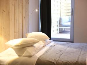 a bed with three pillows on it in a room at Maison Bacou Cité 3 in Carcassonne