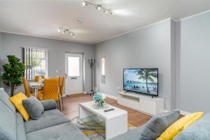 uma sala de estar com um sofá e uma televisão em Large Apartment Near Stonehenge Amesbury Town Centre Smart TVs Netflix FREE PARKING em Amesbury