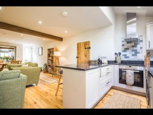 a kitchen with a counter top and a living room at James Cottage in Chelmorton