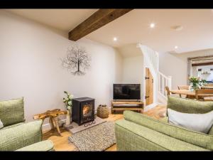 sala de estar con 2 sofás y chimenea en James Cottage, en Chelmorton