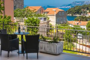 balcón con mesa, sillas y vistas al agua en Apartments Rilovic, City and Sea view apartments, en Cavtat