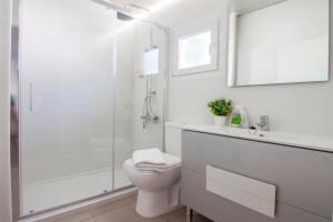 a white bathroom with a toilet and a shower at Alannia Guardamar in Guardamar del Segura