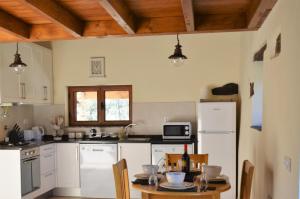 Il comprend une cuisine avec des appareils blancs et un plafond en bois. dans l'établissement Casa Lerryn, à Sertã