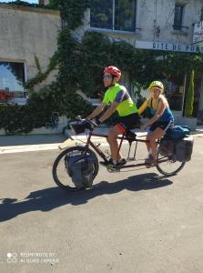 two people riding on a bike trailer on the road at Chambres d'hotes du Port Gautier in Vouvray-sur-Loir