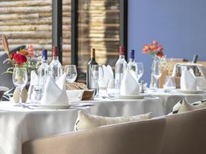 a group of tables with wine bottles and glasses at Hotel des Quinconces Bordeaux Centre in Bordeaux