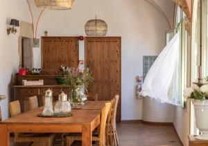 uma sala de jantar com uma mesa de madeira e cadeiras em El Palauet de Monells - Adults Only em Monells