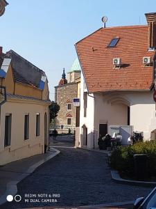 un callejón con dos edificios y un edificio con techo rojo en Centrum Szíve, en Pécs