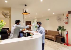 two men standing at a counter in a hospital room withhazardagents at Hotel Sparsh Inn - Chandkheda in Ahmedabad