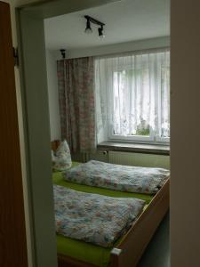 クアオルト・オーバーヴィーゼンタールにあるPension Glückaufの窓付きの小さな部屋のベッド2台