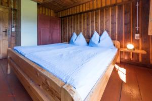 ein Schlafzimmer mit einem Bett mit einer Holzwand in der Unterkunft Almliesl MITT-396 in Mittersill