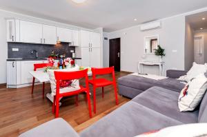 uma cozinha e uma sala de estar com mesa e cadeiras em Nel Centro City Apartment em Rovinj