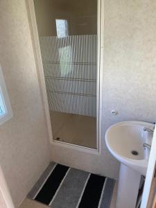 a bathroom with a sink and a glass shower at Eastgate Fantasy Islands Static Caravan Park in Ingoldmells