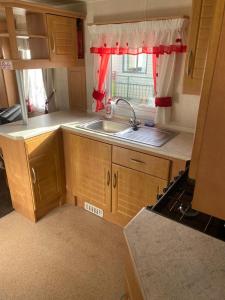 a small kitchen with a sink and a window at Eastgate Fantasy Islands Static Caravan Park in Ingoldmells