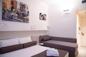 ein kleines Zimmer mit einem Bett und einem Sofa in der Unterkunft Residenza Pantaleo in Rom