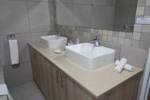 a bathroom with two sinks and a mirror at Dunton Guest House in Johannesburg