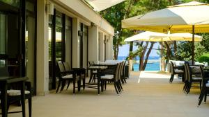 an outdoor restaurant with tables and chairs and umbrellas at Hotel Flores in Poreč