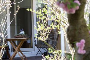 a porch with a table and a chair and flowers at Altstadtzauber Amberg in Amberg