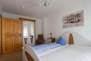 a bedroom with a white bed and a wooden door at Altstadtzauber Amberg in Amberg