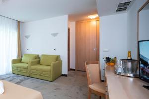 a living room with a yellow chair and a table at Hotel Flores in Poreč